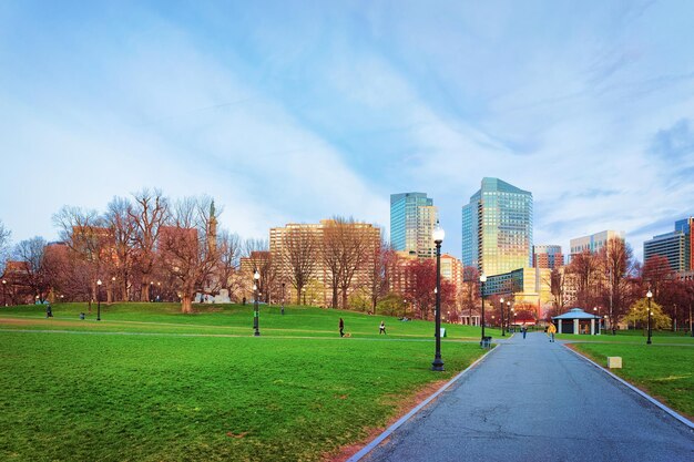 Skyline e parco pubblico Boston Common, nel centro di Boston, Massachusetts, Stati Uniti. Persone sullo sfondo. La sera tardi