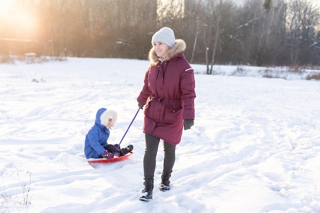 Slittino in inverno, la madre porta la figlia su una slitta sul ghiaccio