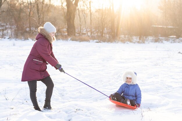 Slittino in inverno, la madre porta la figlia su una slitta sul ghiaccio