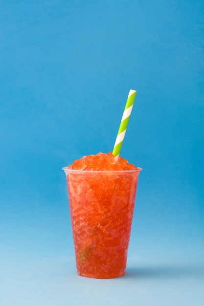 Slushie alla fragola sulla tavola blu