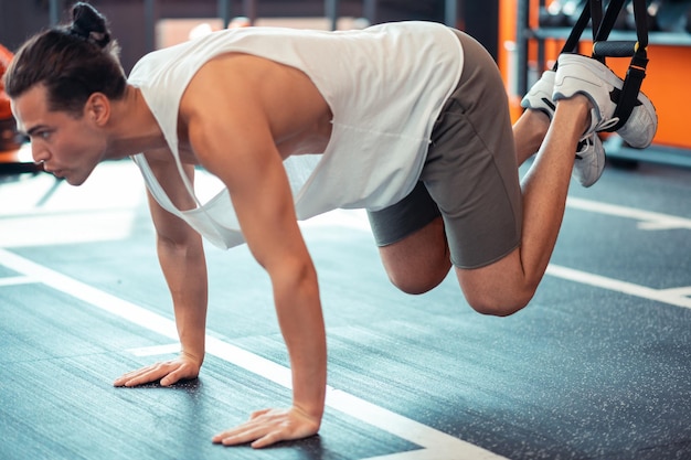 Smart bell'uomo che si allena su cinturini per il fitness