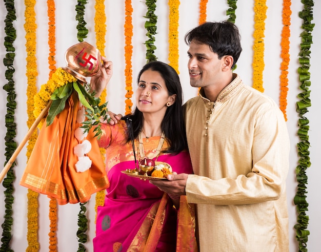 Smart Indian giovane coppia che esegue Gudi Padwa Puja in panni tradizionali e pooja thali. È un capodanno indù celebrato in tutta l'India