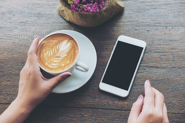 Smart phone mockup sul tavolo con tazza di caffè