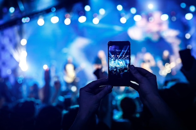 Smart phone tenuto in mano che filma un concerto