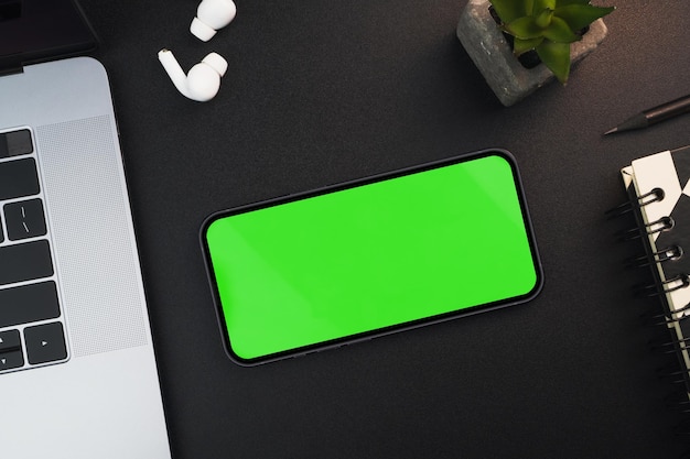 Smartphone con schermo verde su sfondo nero tavolo Ambiente d'ufficio Chroma Key