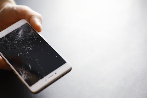 Smartphone con touch screen rotto. Il cellulare è rotto. Il telefono si è schiantato. Sostituzione di vetri rotti su un telefono cellulare. Riparazione smartphone.