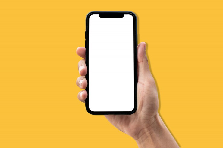 Smartphone della tenuta della mano su fondo giallo