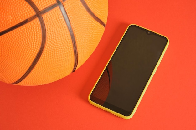 Smartphone e basket su sfondo rosso mck up spazio di copia