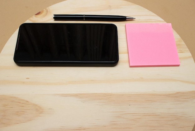 Smartphone e penna vicino al blocco note sull'ufficio