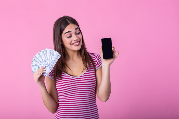 Smartphone e soldi attraenti della tenuta della donna