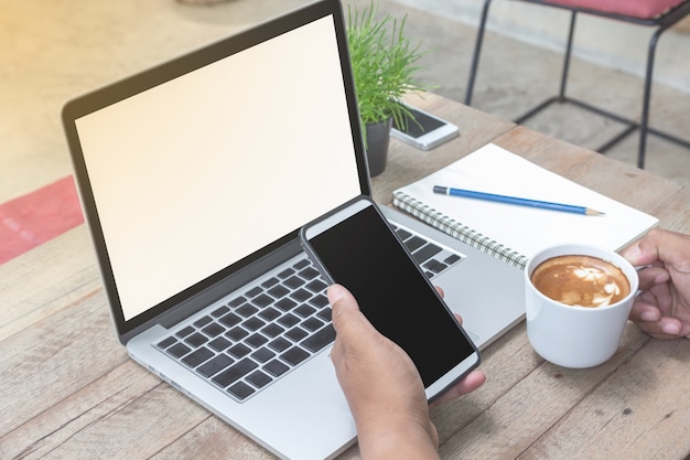 smartphone e tazza di caffè della mano dell&#39;uomo