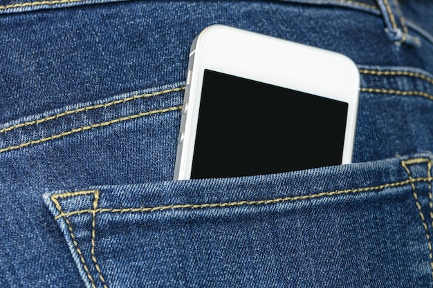 Smartphone generico bianco nelle tasche posteriori dei jeans