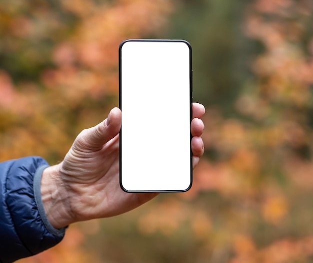 Smartphone mockup sullo schermo del telefono cellulare mock up in mano su sfondo giallo autunnale