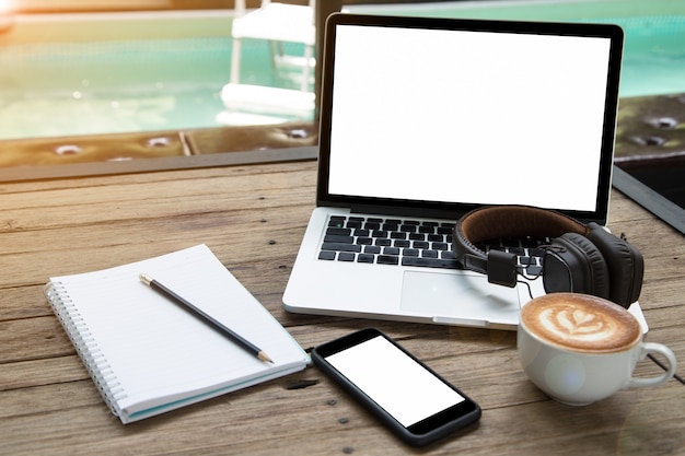 smartphone notepad della tazza di caffè del computer portatile e cuffia a bordo piscina