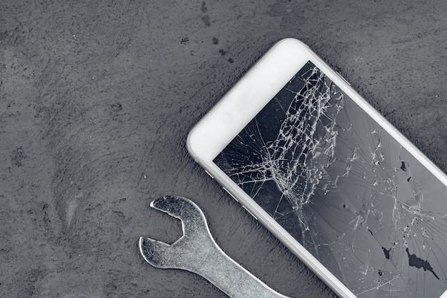 Smartphone si è schiantato con strumenti di riparazione su superficie grigia
