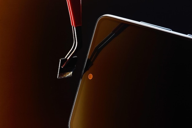 Smartphone spento e micro sd estratta con una pinzetta