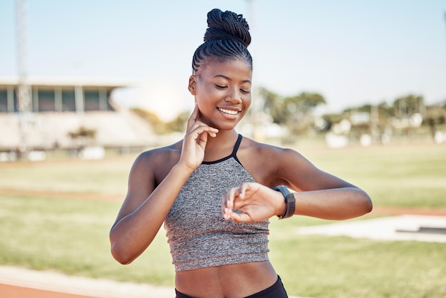 Smartwatch fitness e frequenza cardiaca con donna nera che corre sulla pista dello stadio per allenare lo sprint o la resistenza alla resistenza Tracker degli obiettivi e app di avanzamento con tempo di controllo del corridore per l'allenamento cardio