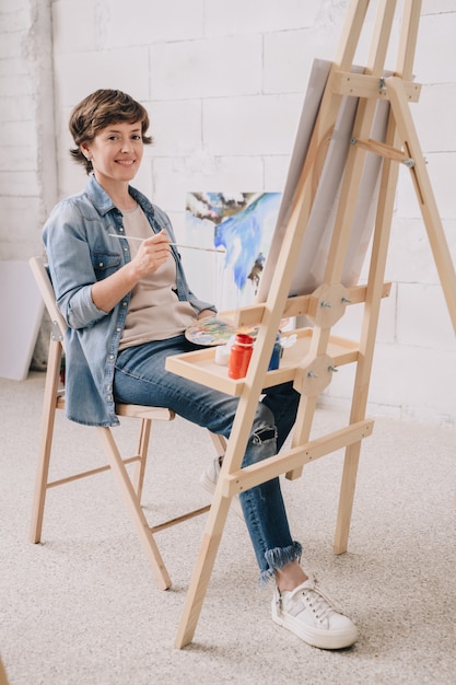 Smiling Female Artist di Easel