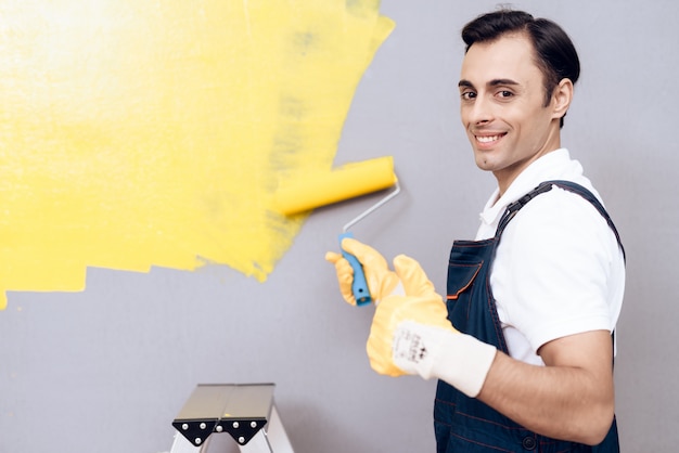 Smiling Man on Labber in Uniform Paint Gray Wall.