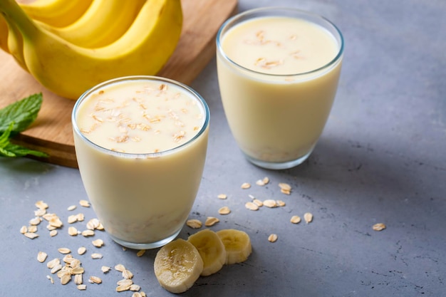 Smoothie vegano a base di banane e farina d'avena in barattolo di vetro su uno sfondo chiaro Alimenti sani