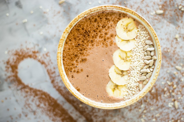 Smoothies della Cioccolato-banana in una ciotola su un fondo concreto grigio