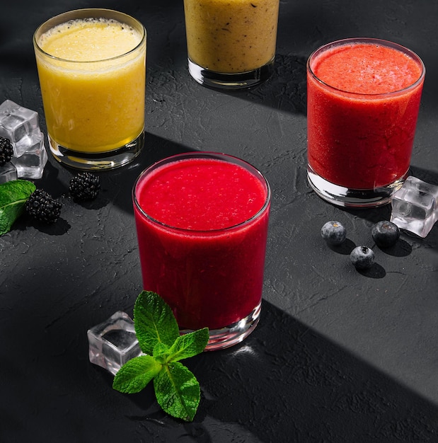 Smoothies di fragole, lamponi e banane su pietra