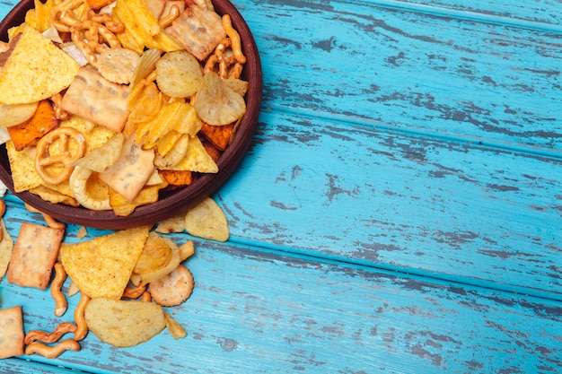 Snack alla birra come cracker, patatine, biscotti su uno sfondo di superficie in legno