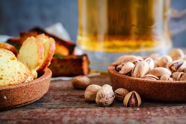 Snack alla birra, pistacchi, fette biscottate con aneto e un boccale di birra leggera