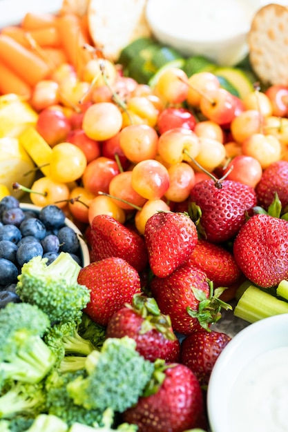 Snack board con frutta fresca, verdura, cracker e salse.