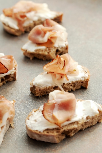 Snack con pane tostato, formaggio alla crema e salami