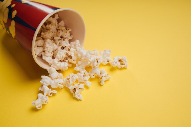 Snack di popcorn in una tazza su sfondo giallo