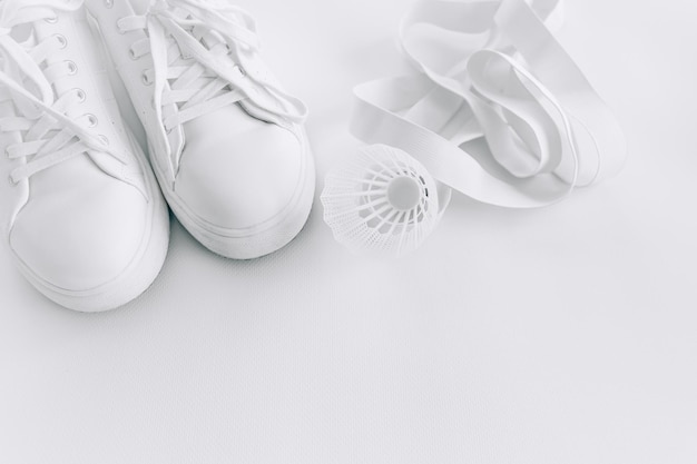 Sneakers bianche e oggetti sportivi su sfondo bianco