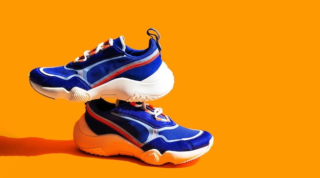 Sneakers blu su sfondo arancione Calzature casual da strada per scarpe sportive alla moda