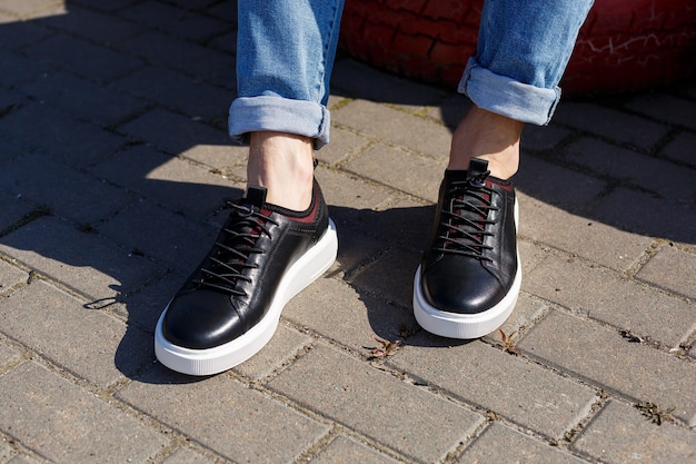 Sneakers o scarpe da uomo in vera pelle sul primo piano delle gambe degli uomini.