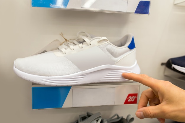Sneakers sportive bianche su uno scaffale in un negozio di scarpe