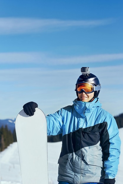 Snowboarder con action camera su un casco Occhiali da sci con il riflesso delle montagne innevate