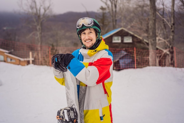 Snowboarder maschio in una stazione sciistica in inverno
