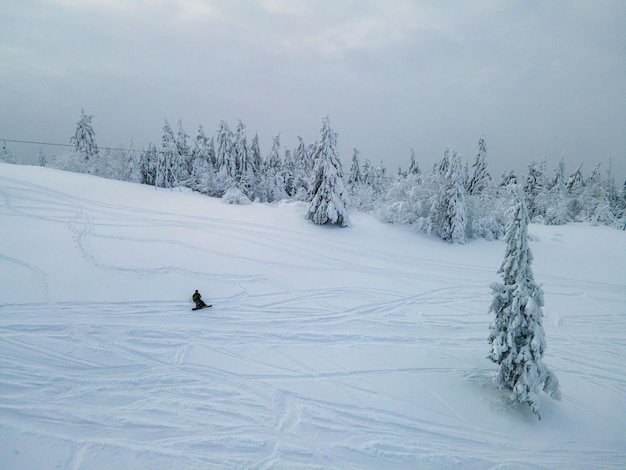 Snowboarder uomo godendo il tramonto sopra le montagne