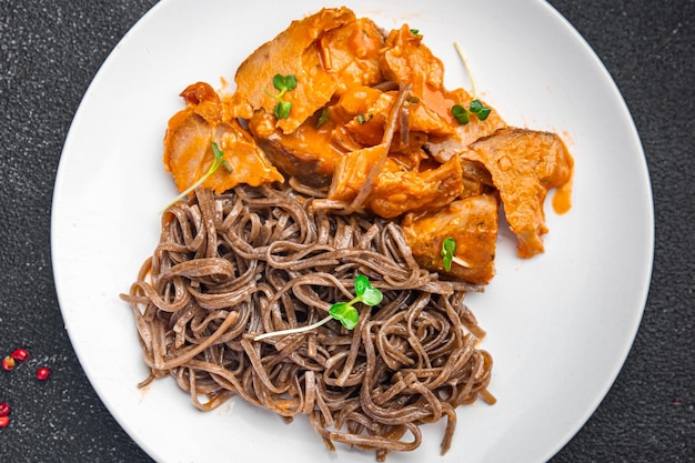 Soba tagliatelle di grano saraceno carne salsa di pomodoro pasto spuntino sul tavolo copia spazio