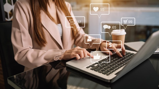 Social media e marketing icone virtuali concetto dello schermo primo piano della tastiera di digitazione della donna d'affari con il laptop