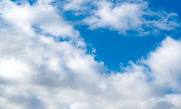 Soffici nuvole bianche contro un cielo blu in una calda giornata di sole Nuvole dolci e lentamente fluttuanti come concetto di una vita tranquilla