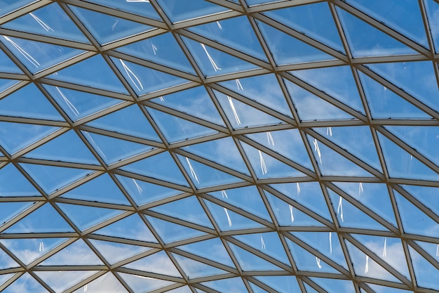 Soffitto a cupola in vetro in un moderno centro commerciale contro un cielo blu