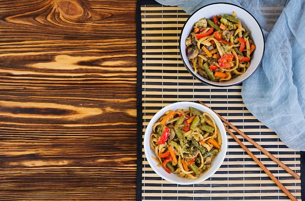 Soffriggere di verdure con le tagliatelle su fondo di legno