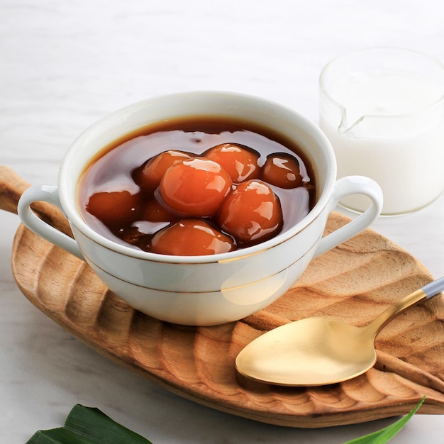 Soft Focus Kolak Biji Salak o porridge di patate dolci in una ciotola bianca su sfondo bianco a base di farina di sago di patate dolci Zucchero di canna e latte di cocco è fatto per Takjil o dessert