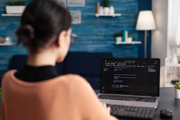 Software di programmazione freelance su laptop. Programmatore che lavora a distanza dall'ufficio di casa. Debug del tester di codice su laptop tramite tastiera. Sviluppatore studente che digita i dati sullo schermo.