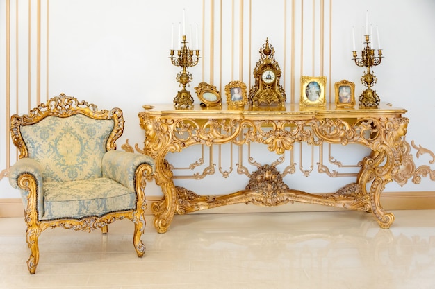 Soggiorno di lusso in colori chiari con dettagli di mobili dorati. Interni classici eleganti