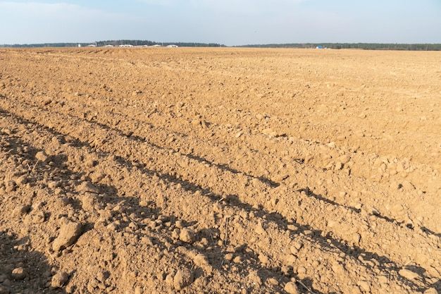 Solchi profondi nel terreno dopo aver lavorato il trattore con l'aratro Aratura del terreno Trattamento dello strato superiore del terreno per saturare il terreno con ossigeno e distruggere i semi e le radici delle erbacce