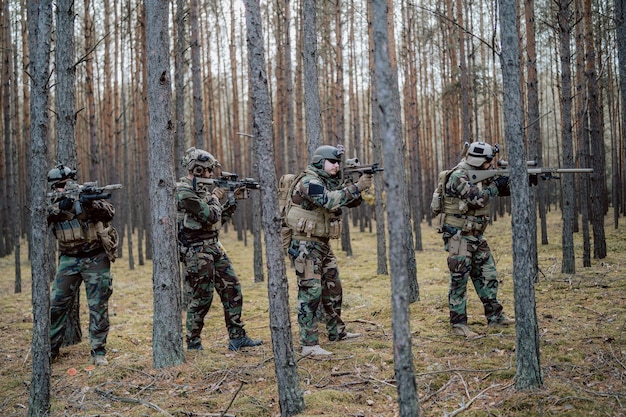 Soldati completamente equipaggiati che indossano un'uniforme mimetica che attaccano i fucili nemici in posizione di tiro