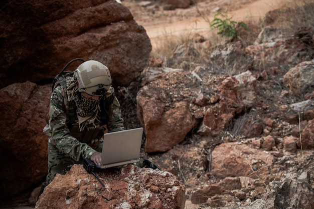 Soldati delle forze speciali in guerra nel desertoPopolo della ThailandiaIl soldato dell'esercito usa il laptop per vedere la mappa con il satelliteUso della radio per la comunicazione durante l'operazione militare