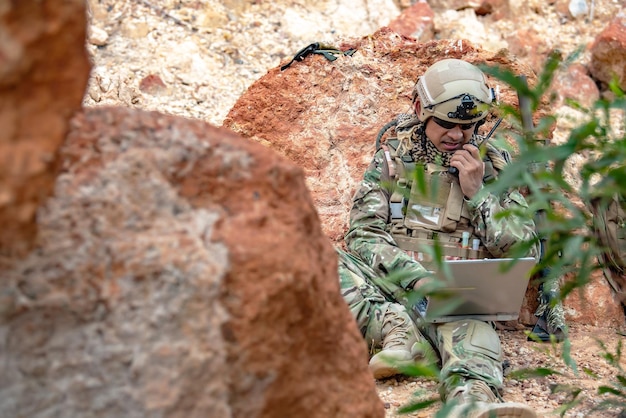 Soldati delle forze speciali in guerra nel desertoPopolo della ThailandiaIl soldato dell'esercito usa il laptop per vedere la mappa con il satelliteUso della radio per la comunicazione durante l'operazione militare